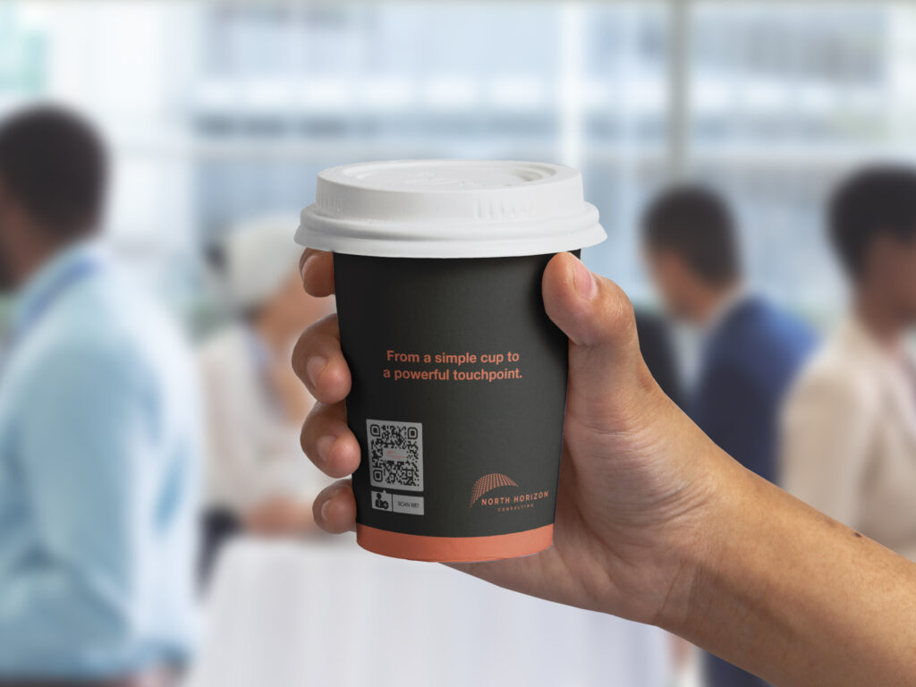 hand holding a coffee mug with a qr code on it