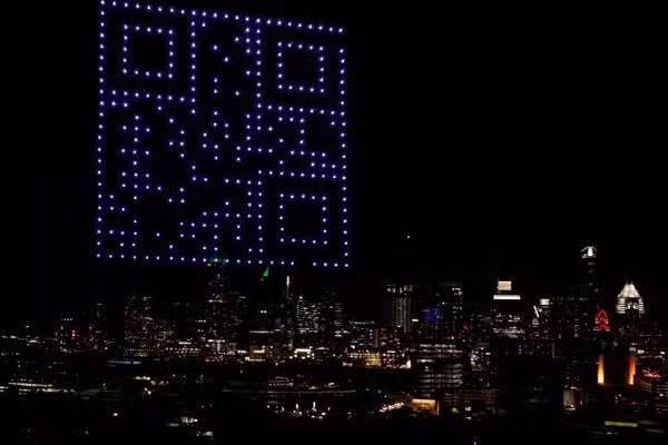 QR code drone show at night over city lights in austin