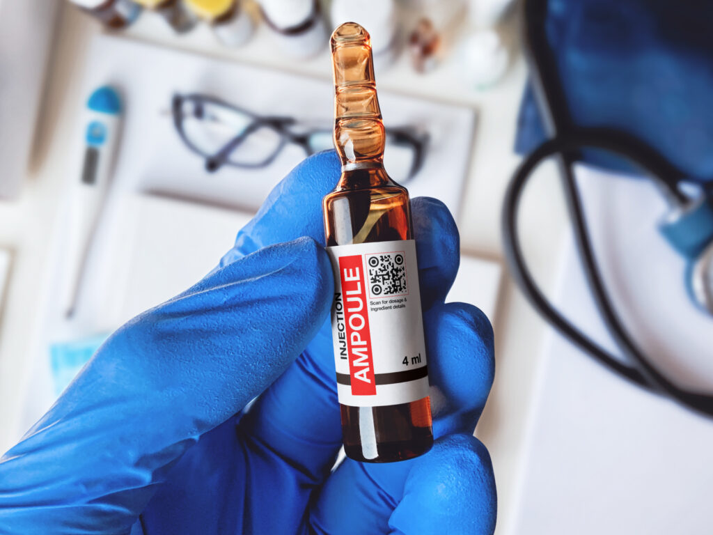 an ampoule injection bottle with a qr code on it in someone's hand